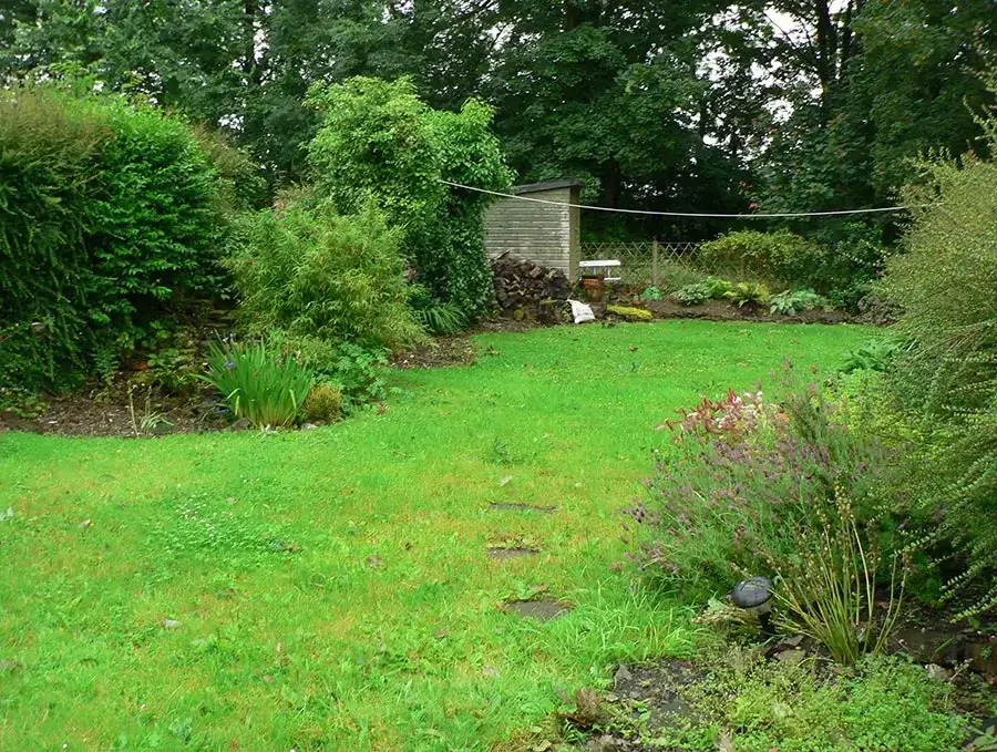 Welsh Cottage Garden Before Landscaping The Welsh cottage garden in 2007, showing a simple rectangular lawn bordered by overgrown shrubs before landscaping began.