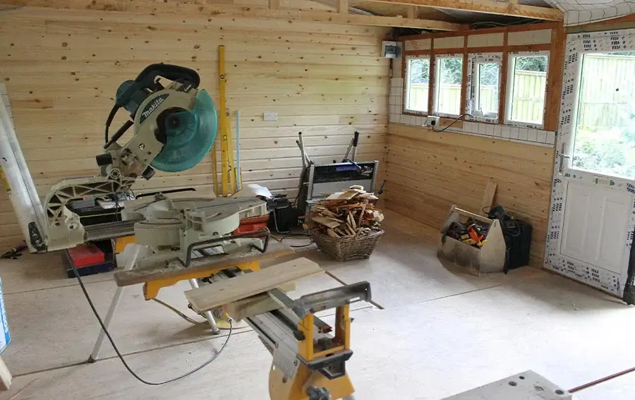 Lily Inspecting the Studio Progress Mid-Renovation Lily the Tibetan Terrier sitting contentedly amidst the ongoing studio renovation, with new double-glazed windows and wall cladding visible.