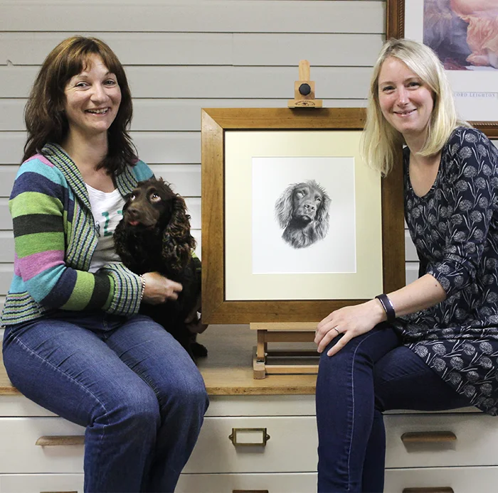 Melanie, Tracey and Moo with her portrait Tracey collecitng per pencil drawing of Moo at our studio with moo the dog.